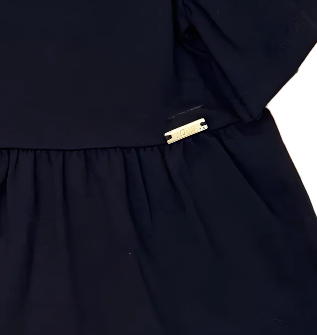 Plaquinha dourada na cintura do vestido
