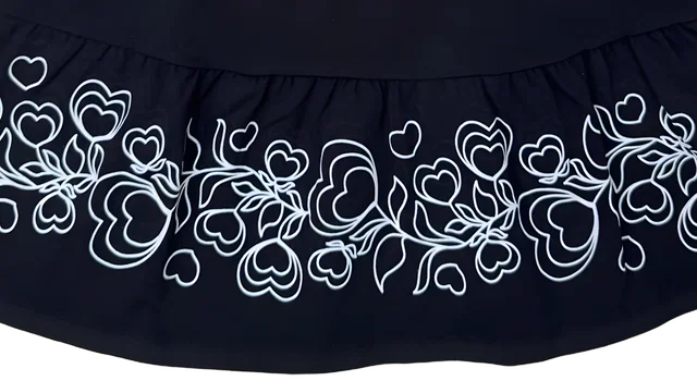 Barra do vestido marinho com estampa de corações em linha branca